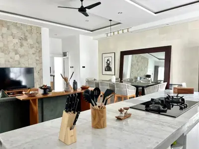 a kitchen and living room with a counter and a table at 3BR Luxury Retreat Umalas with Pool - Villa Theo in Canggu