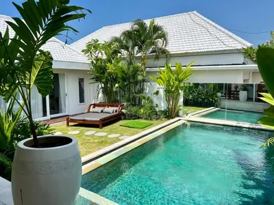 a villa with a swimming pool in front of a house at 3BR Luxury Retreat Umalas with Pool - Villa Theo in Canggu