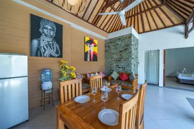 a dining room with a table and a refrigerator at Villa Dream Seminyak in Seminyak