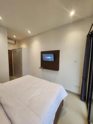 a bedroom with a bed and a tv on the wall at Bali Thousand Island in Pesanggaran