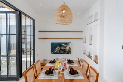 a dining room with a long table and chairs at Villa Bellora by Pertama Management in Seminyak