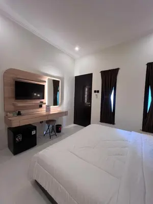 a white bedroom with a large bed and a desk at Summerville Homes in Canggu