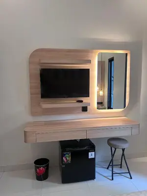 a television on a wall with a mirror and a stool at Summerville Homes in Canggu
