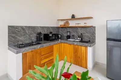 a kitchen with wooden cabinets and a counter top at Dasha 2- Chic 2BR in Canggu in Canggu