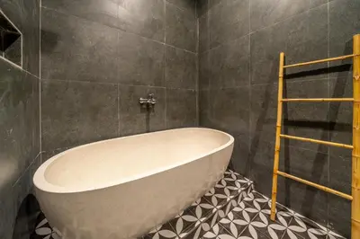a bathroom with a tub and a tiled floor at Dasha 2- Chic 2BR in Canggu in Canggu