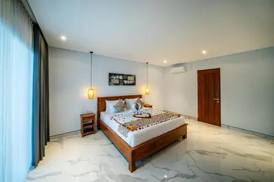 a bedroom with a large bed in a room at Villa Lotus Seminyak in Seminyak
