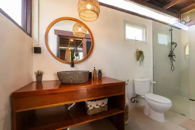a bathroom with a sink and a mirror and a toilet at Pura Villa in Uluwatu in Jimbaran