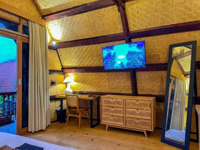 a room with a desk and a television on a wall at Makaha Bungalow in Jimbaran