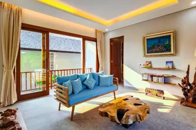 a living room with a blue couch and a table at Belisaria Comfortable 3 BR Private Pool Villa in Sanur