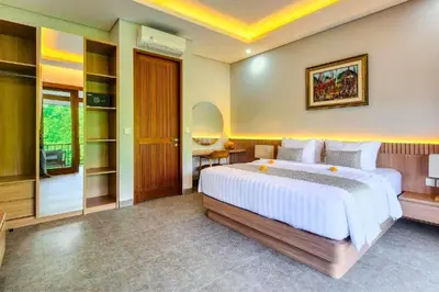 a bedroom with a large white bed and a desk at Belisaria Comfortable 3 BR Private Pool Villa in Sanur