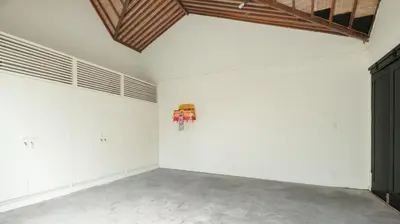 an empty room with white walls and a wooden ceiling at Villa Merta Sari 8 by Villa Finder in Seminyak