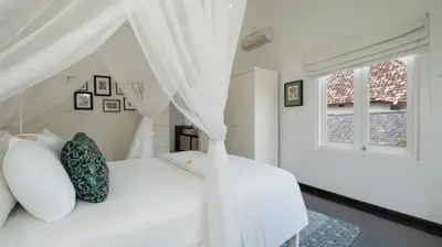 a bedroom with a white bed with a canopy at Villa Merta Sari 8 by Villa Finder in Seminyak