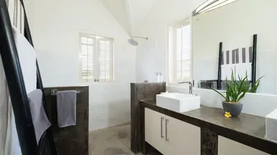a white bathroom with a sink and a mirror at Villa Merta Sari 8 by Villa Finder in Seminyak