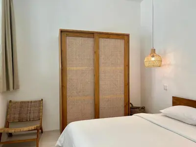 a bedroom with a bed and a window and a chair at 1BR Tropical Villa With Pool - Canggu - Berawa in Canggu