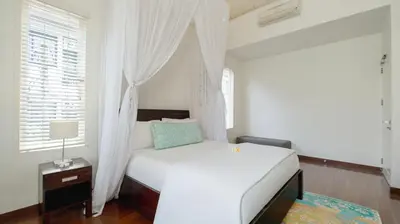 a bedroom with a white bed and a window at Villa Merta Sari 10 by Villa Finder in Seminyak