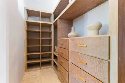 a closet with a wooden dresser and shelves at Luxury Villa in Berawa Beach 3BR - Canggu in Canggu
