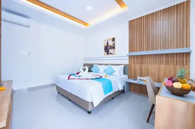 a bedroom with a bed and a desk with a desk at Zelene Elegant 3 BR Private Pool Villa in Seminyak