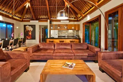 a living room with brown leather couches and a table at Calista Peaceful 4 BR Private Pool Villa in Canggu