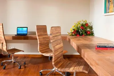 a wooden table with two chairs and a laptop at Calista Peaceful 4 BR Private Pool Villa in Canggu