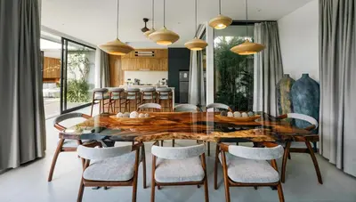 a dining room with a wooden table and chairs at Villa Olivia - Umalas in Kerobokan