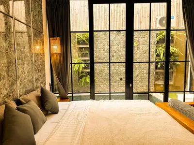 a bedroom with a large bed with a large window at Villa Mikhail Seminyak in Seminyak