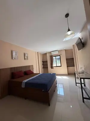 a bedroom with a bed and a table in it at Okie house hotel in Legian
