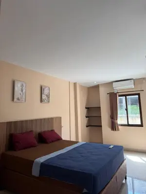 a bedroom with a bed with blue sheets and a window at Okie house hotel in Legian
