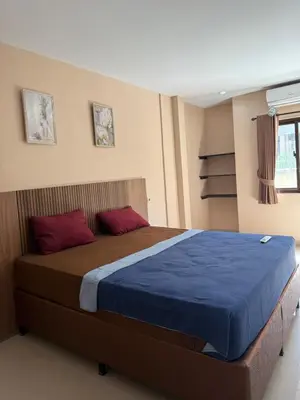 a bedroom with a bed with blue sheets and red pillows at Okie house hotel in Legian