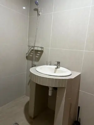 a bathroom with a sink and a shower at Okie house hotel in Legian