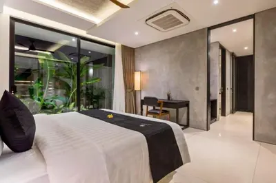 a bedroom with a large white bed and a desk at Tanaya Luxury 4 BR Private Pool Villa in Canggu