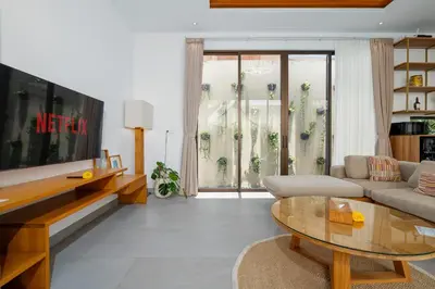 a living room with a couch and a table at Villa Hattala - Luxury Modern Villa in Prime Berawa with Air-Conditioned Living Space in Canggu