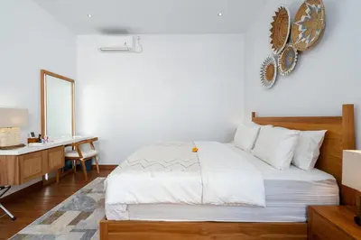 a bedroom with a bed and a desk and a mirror at Villa Hattala - Luxury Modern Villa in Prime Berawa with Air-Conditioned Living Space in Canggu