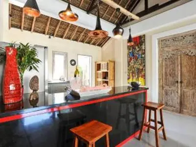 a bar in a room with two chairs and a table at Bamboo Moon Villas in Sanur