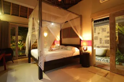a bedroom with a canopy bed in a room at Bamboo Moon Villas in Sanur