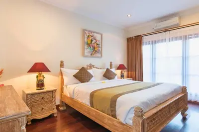 a bedroom with a large bed and a window at Andina Spacious Garden 4 BR Private Pool Villa in Seminyak
