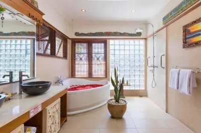 a bathroom with a large tub and a sink at Andina Spacious Garden 4 BR Private Pool Villa in Seminyak