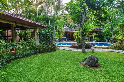 a yard with a pool and a house at Andina Spacious Garden 4 BR Private Pool Villa in Seminyak