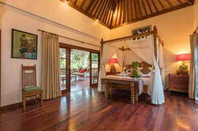 a bedroom with a canopy bed in a room at Andina Spacious Garden 4 BR Private Pool Villa in Seminyak