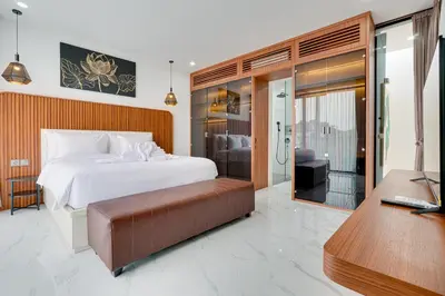a bedroom with a bed and a desk with aaptop at Modern 2BR Villa Reisi Malindra M12 in Denpasar in Kerobokan