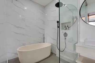 a white bathroom with a tub and a shower at Modern 2BR Villa Reisi Malindra M12 in Denpasar in Kerobokan