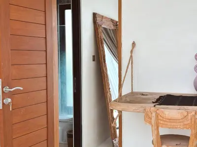 a room with a wooden door and a wooden shelf at Villa Lilla and Sauna in Canggu
