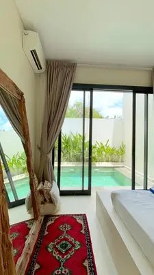a bedroom with a bed and a swimming pool at Villa Lilla and Sauna in Canggu