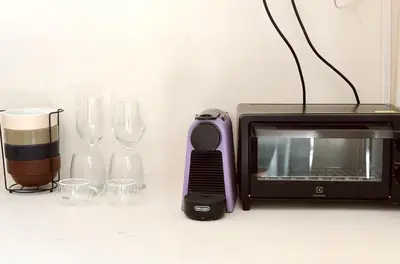 a microwave and a toaster and glasses on a counter at Villa Lilla and Sauna in Canggu