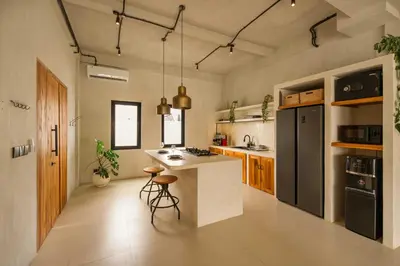 a kitchen with a island and a black refrigerator at Modern 1BR Villa with Private Pool in Kerobokan