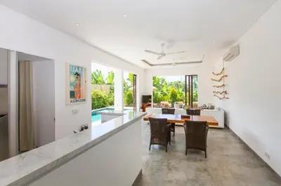 a dining room and living room with a table and chairs at Orvala Comfortable 2 BR Private Pool Villa in Seminyak