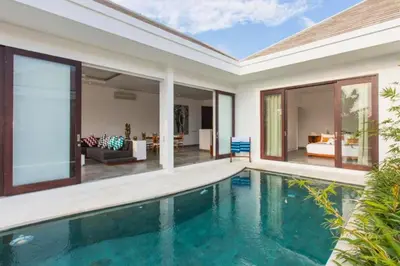 a villa with a swimming pool and a living room at Orvala Comfortable 2 BR Private Pool Villa in Seminyak
