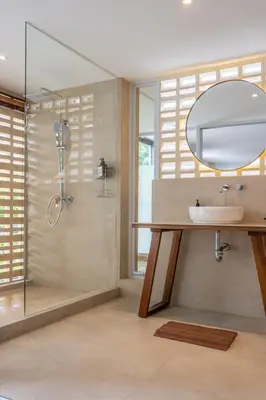 a bathroom with a sink and a shower with a mirror at Springleaf Villa in Nusa Dua
