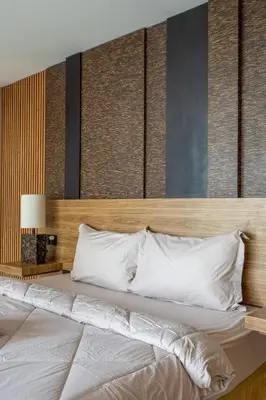 a bedroom with a large bed with a wooden headboard at Springleaf Villa in Nusa Dua