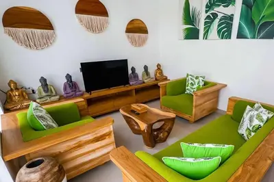 a living room with green furniture and a flat screen tv at Luxurious Semeniyak new 2BR villa with a pool in Seminyak