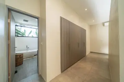 a bathroom with a large sliding door and a tub at Lotus Villa-Cozy 3BR in Canggu in Kerobokan
